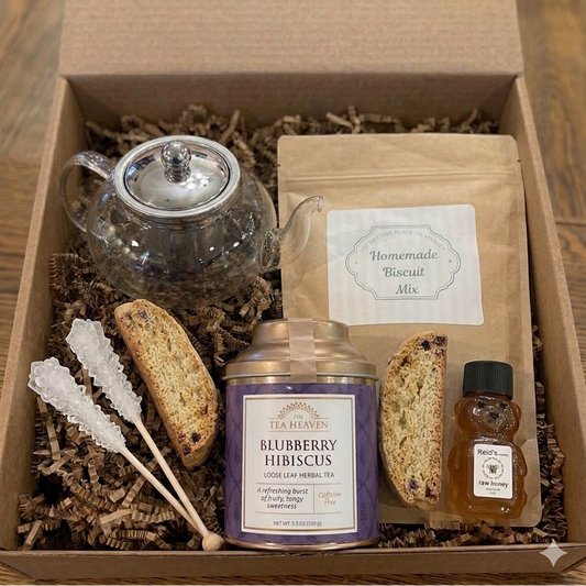 Gift box with tea, biscotti, and other items on a wooden surface