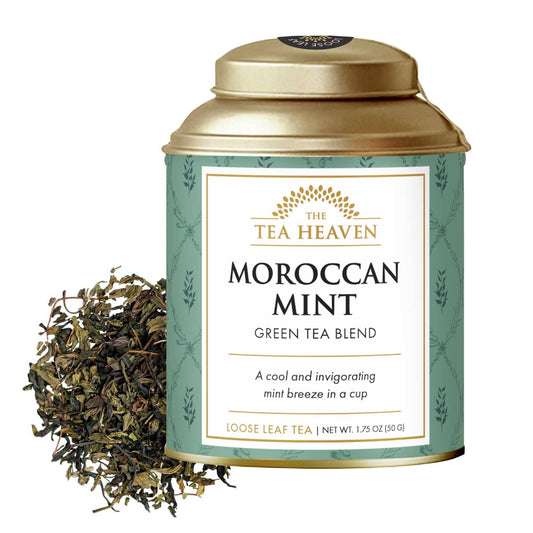 Tea canister labeled 'Moroccan Mint' from The Tea Heaven with loose leaf tea on a white background